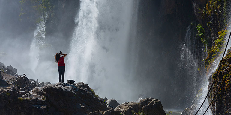 Frau vor großem Wasserfall